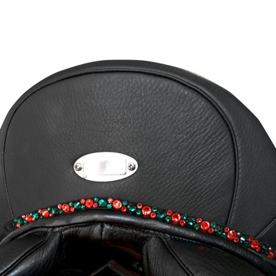 Sela preta de couro com decoração de pérolas vermelhas e verdes e placa metálica oval