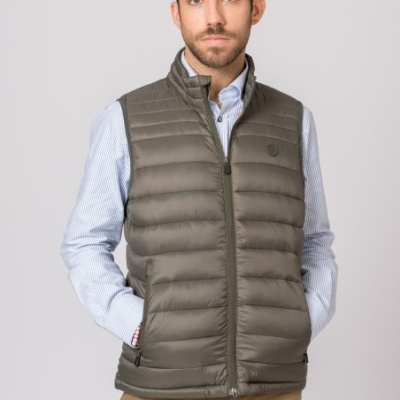 Colete masculino verde-oliva acolchoado com camisa azul às riscas e calças castanhas