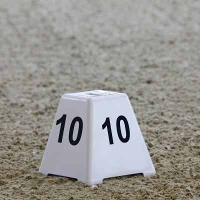 Cone branco com o número 10 em preto sobre areia