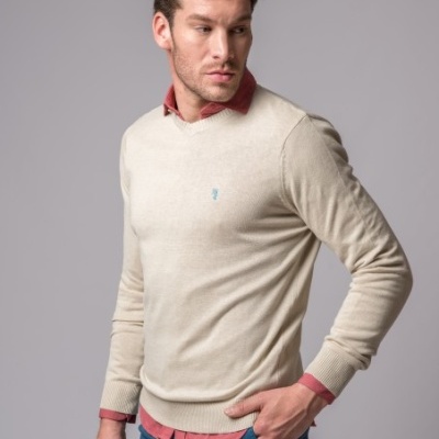 Homem com camisola bege de malha fina e camisa vermelha