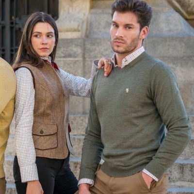 Homem e mulher com roupa casual elegante, incluindo colete tweed e camisola verde