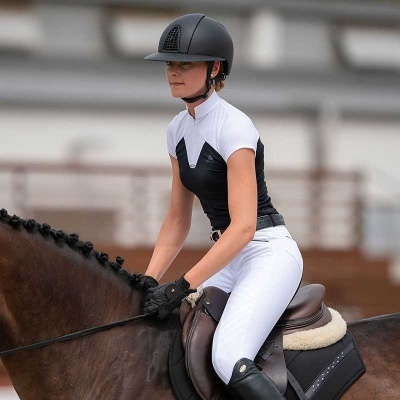 Mulher em equipamento de equitação montada em cavalo castanho com sela preta