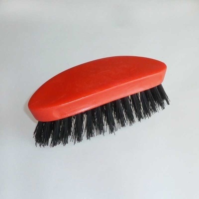 Escova vermelha com cerdas pretas sobre fundo branco