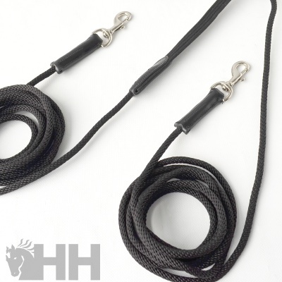 Duas trelas pretas para cão com ferragens metálicas e couro, sobre fundo branco com logótipo HH.