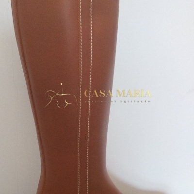 Bota alta de couro castanho com costura branca em fundo branco