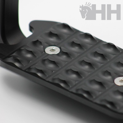 Pedal metálico preto com textura antiderrapante e parafusos visíveis