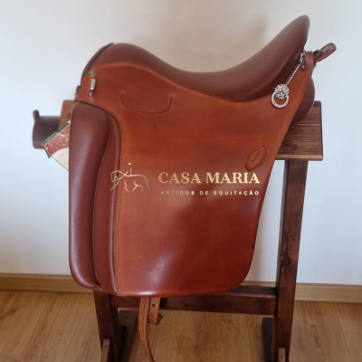 Sela de equitação castanha em couro numa madeira