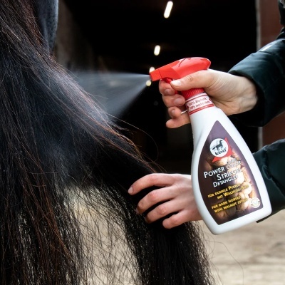 Spray Keel Power Strength Detangler a ser aplicado no pelo de um cavalo negro num estábulo