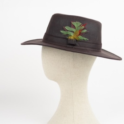 Chapéu fedora castanho em couro com penas coloridas numa cabeça de manequim branca