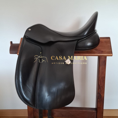 Sela de equitação de couro preto sobre suporte de madeira