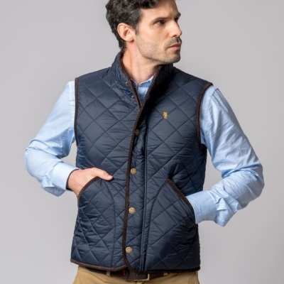 Colete acolchoado azul escuro com botões metálicos usados por homem