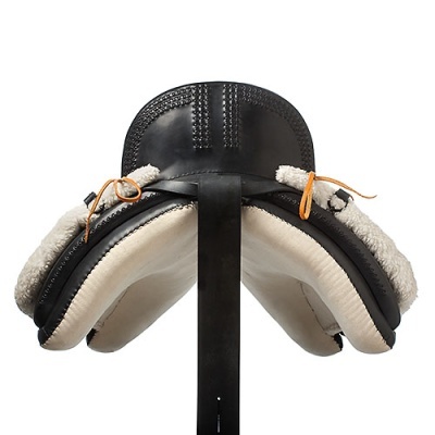 Sela de equitação preta com forro de lã branca em suporte