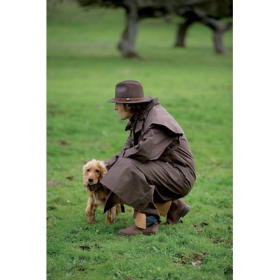 Homem com casaco e chapéu castanhos ao ar livre com cão castanho