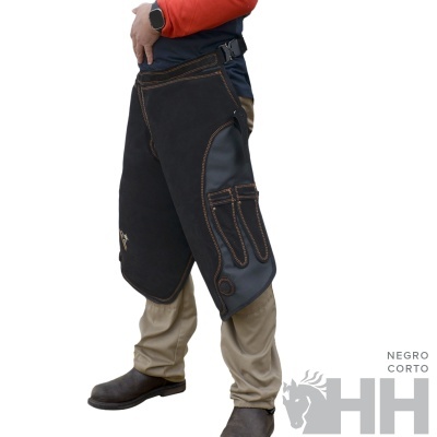 Avental preto curto com bolsos reforçados e costuras castanhas usado por cima de calças bege e camisa vermelha