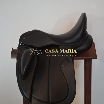 Sela de equitação preta em pele sobre suporte de madeira