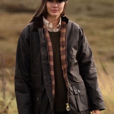 Casaco impermeável castanho escuro com forro interior xadrez e bolso frontal, usado por mulher com boné cinzento
