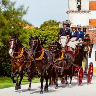 Carruagem puxada por quatro cavalos com pessoas vestidas formalmente
