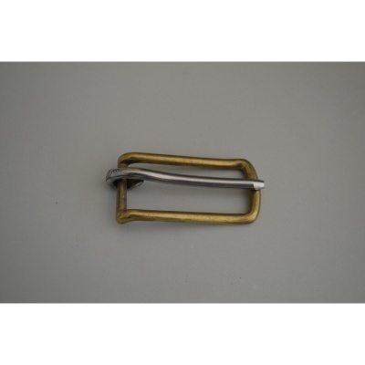 Fivela de metal dourada e prateada sobre fundo cinza