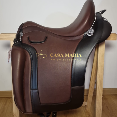 Selim de equitação castanho e preto com detalhes metálicos, sobre estrutura de madeira