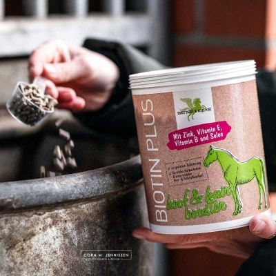 Recipiente de suplemento para cavalos Biotin Plus com rótulo colorido e pellets a serem despejados