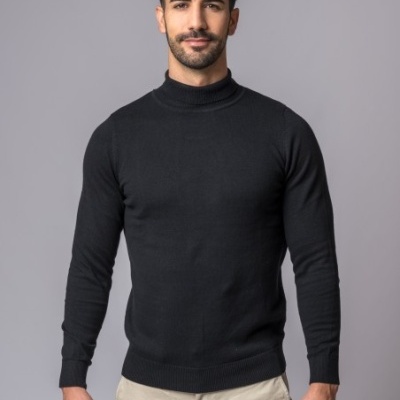 Homem com camisola preta de gola alta e calças bege claras