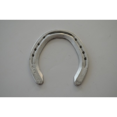 Ferradura metálica prateada com furos sobre fundo branco