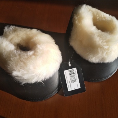 Polainas pretas com pelo branco e etiqueta com código de barras