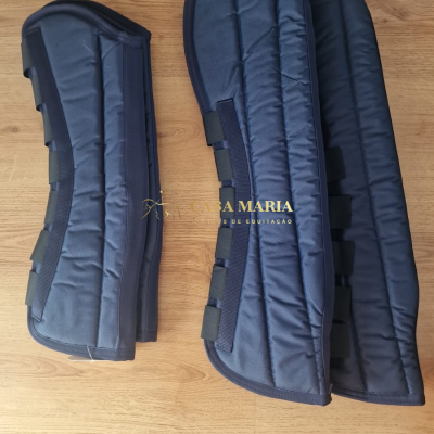 Protetores acolchoados azuis escuros para equitação com tiras de velcro sobre piso de madeira