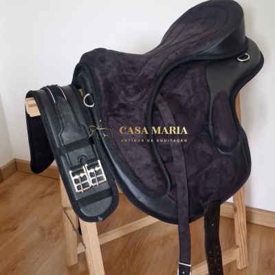 Sela preta de equitação com acessórios sobre suporte de madeira