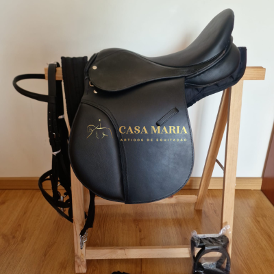 Sela de equitação preta em couro sobre suporte de madeira com acessórios e rédeas pretas.