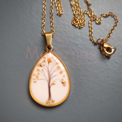 Colar dourado com pendente em forma de gota com imagem de árvore e flores douradas