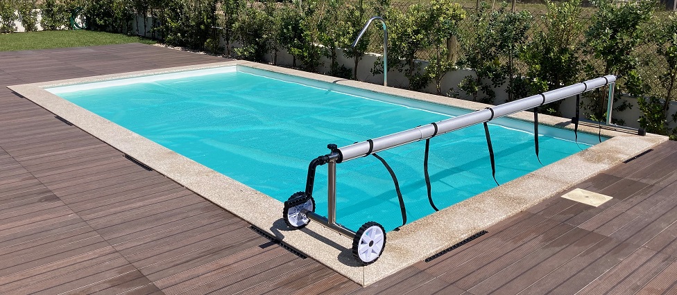 Piscina exterior retangular com cobertura enrolada e pavimento de madeira