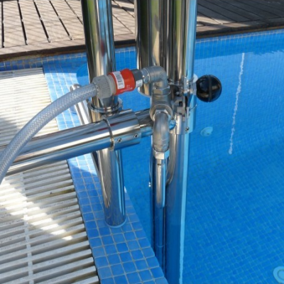 tubagem de aço inoxidável com mangueira junto a piscina de azulejos azuis