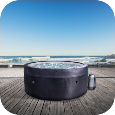 Banheira de hidromassagem preta redonda exterior com textura de vime numa plataforma de madeira junto ao mar