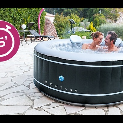 Banheira de hidromassagem insuflável preta Montana num terraço de pedra com casal dentro