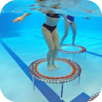 Trampolins pequenos subaquáticos em piscina com duas pessoas