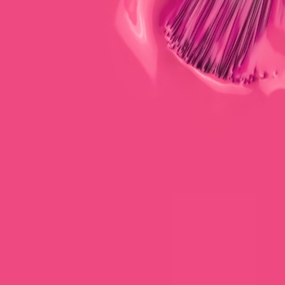 Pincéis de maquilhagem com cabo metalizado sobre fundo cor-de-rosa brilhante.