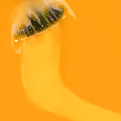 Fatias de kiwi imersas em líquido amarelo alaranjado