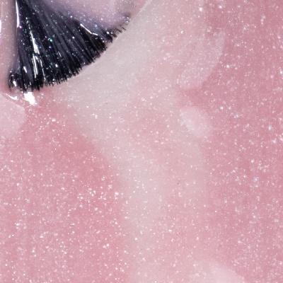 Pincel aplicando verniz rosa brilhante com glitter