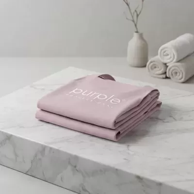 Saia de tecido rosa com texto blanca sobre bancada de mármore.