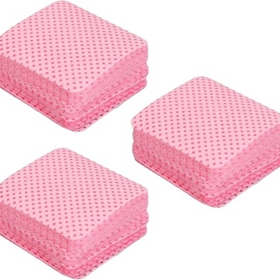 Pilhas de lenços de papel quadrados cor-de-rosa com padrão de pequenos quadrados.