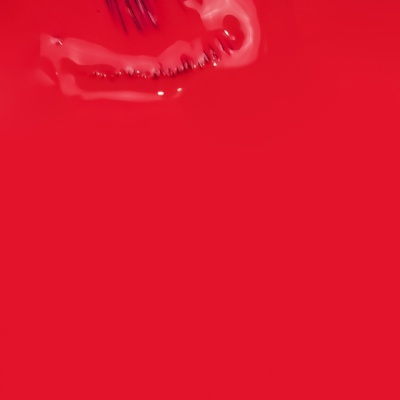 Grampo metálico prateado sobre fundo vermelho