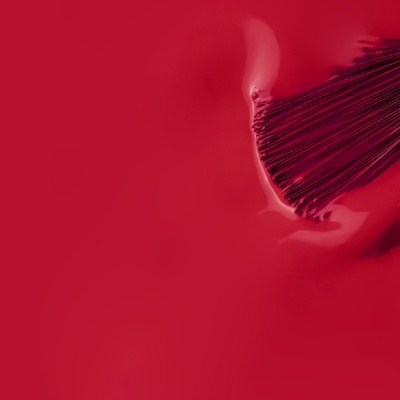 Pincel a espalhar verniz vermelho brilhante
