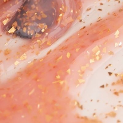 Close-up de gel cosmético rosa com partículas douradas