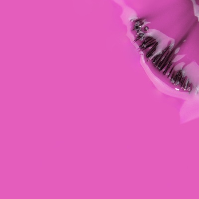 Pente preto com dentes finos coberto por substância branca sobre fundo cor-de-rosa