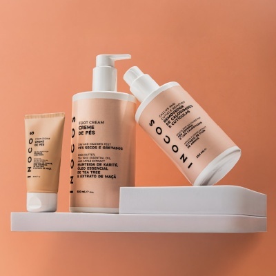 Produtos para os pés INOCOS com embalagem bege e branca em prateleira branca