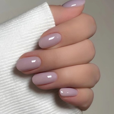 Mão com unhas lilás claras e manga branca canelada