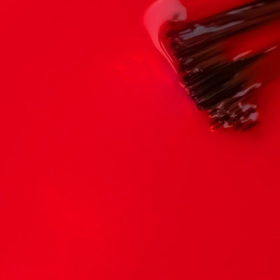 Pincel com tinta vermelha sobre superfície vermelha
