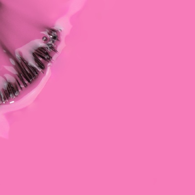 Lábio com verniz rosa brilhante e partículas pretas, fundo rosa