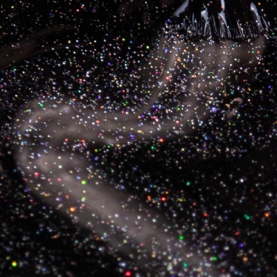 Pincel a aplicar verniz de unhas preto com glitter multicolorido